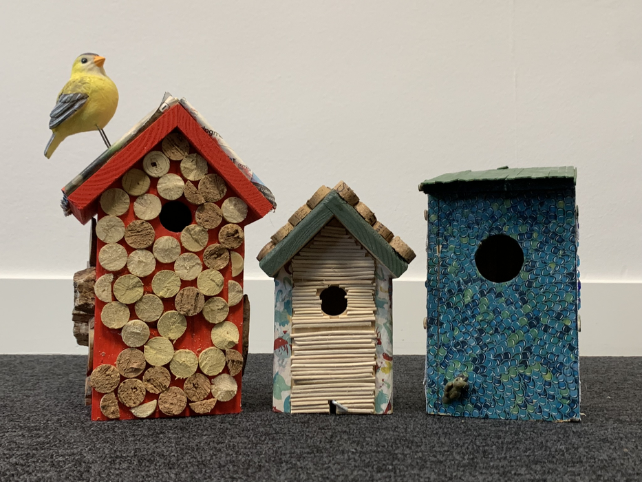 Gekleurde vogelhuisjes met kurk en papierrolletjes